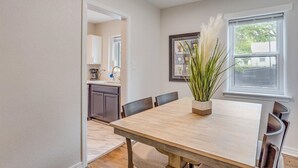 A dining area with a wooden table, chairs, and a potted plant. - Nearby Wesley. Pickle Ball + Family Fun! (Wichita)