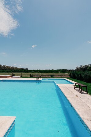 A rectangular swimming pool with clear blue water, surrounded by a concrete deck. - La Santina Posada & Experiencia de Campo (Río Tala)