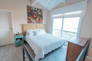 A bedroom with a bed, a nightstand, a dresser, a painting, and a balcony view. - La Santina Posada & Experiencia de Campo (Río Tala)