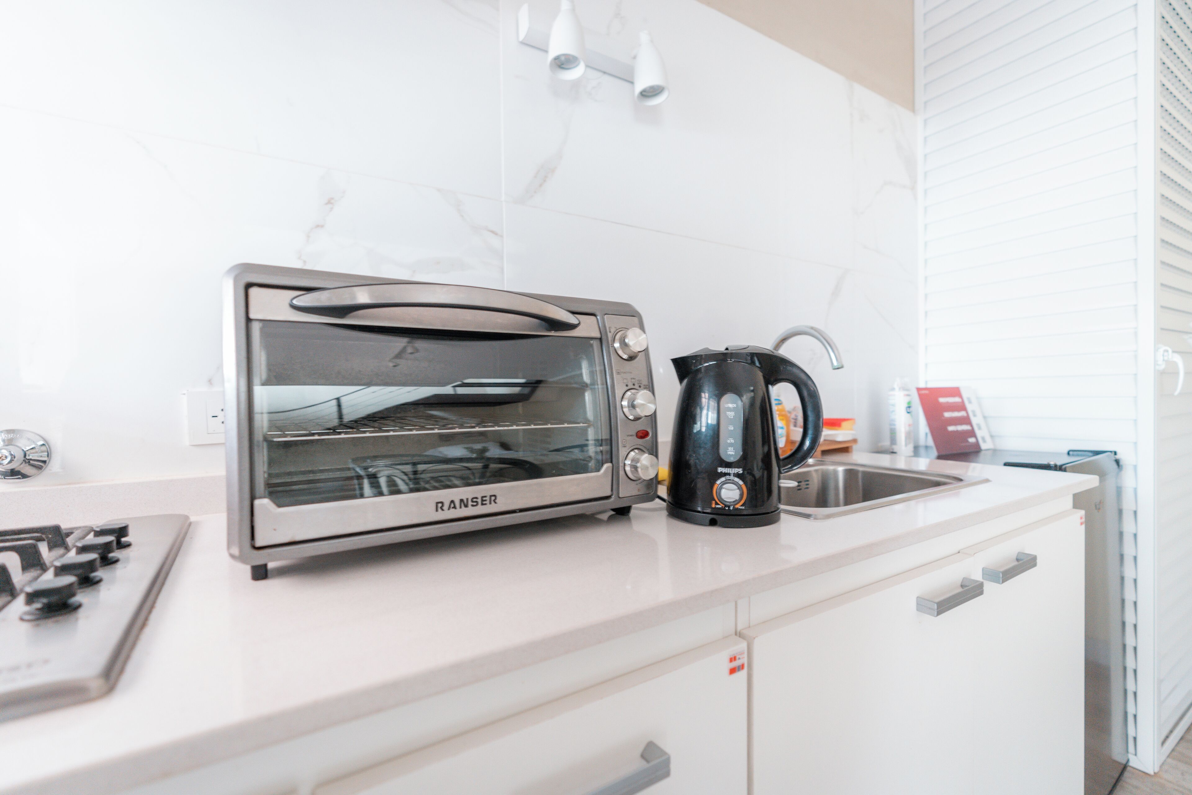 Eine Küche mit einem RANSEK-Toaster, einer Kaffeemaschine und einem Spülbecken.