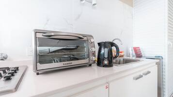 Eine Küche mit einem RANSEK-Toaster, einer Kaffeemaschine und einem Spülbecken.