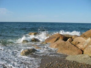 A rocky shoreline with waves crashing against the rocks. - 18 Great Hill Rd (Sandwich)