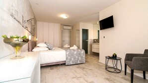 A modern bedroom with a bed, bedside table, and a TV mounted on the wall. - Beachfront Villa Atlantis with Pool (Kaštel Štafilić)