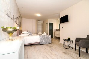 Ein modernes Schlafzimmer mit Bett, Nachttisch und einem an der Wand befestigten Fernseher.