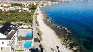 A coastal hotel with a pool, a beach, and a view of the sea and mountains. - Beachfront Villa Atlantis with Pool (Kaštel Štafilić)
