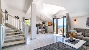 Ein geräumiger Wohnbereich mit Treppe, Essbereich und Balkon mit Blick.