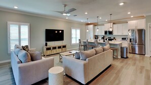 A modern living room with a sofa, TV, and a small round table. - Lost Key Villas #14367 by Southern Vacation Rentals (Pensacola)
