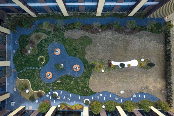 An aerial view of a landscaped rooftop with pathways, water features, and greenery. - Days Inn by Wyndham Yangzhou Guangling (Yangzhou)