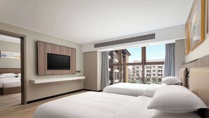 A hotel room with two beds, a mounted TV, and a large window offering a city view. - Days Inn by Wyndham Yangzhou Guangling (Yangzhou)