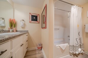 A bathroom with a sink, mirror, towel rack, and shower curtain. - Hello Sunshine, 60 yards from the beach (Destin)