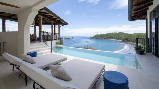 A modern infinity pool with a view of a beach and ocean. - Las Catalinas- Spectacular views- breakfast service, Casa Chameleon's neighbor (Las Catalinas)
