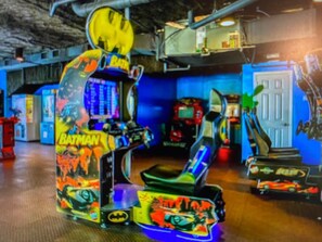 Ein Batman-Automata im Spielhallenstil in einem Raum mit blauen Wänden und verschiedenen anderen Spielautomaten.