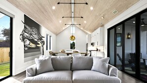 Un interior moderno con un sofá grande, un área de comedor y una cocina.
