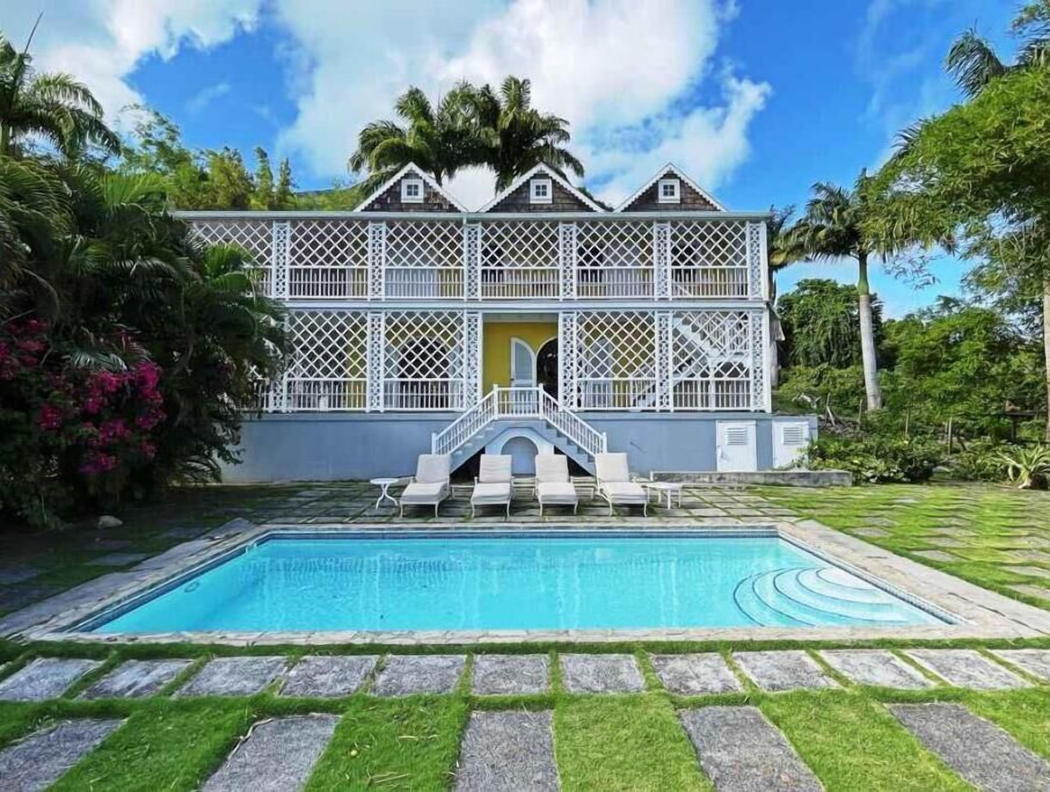 Un bâtiment à deux étages avec une piscine à l’avant.