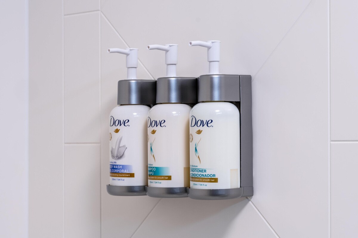 Three Dove personal care products mounted on a wall.