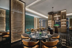 A modern dining area with round tables, checkered chairs, and a decorative ceiling fan. - Crowne Plaza Shangluo (Shanglou)