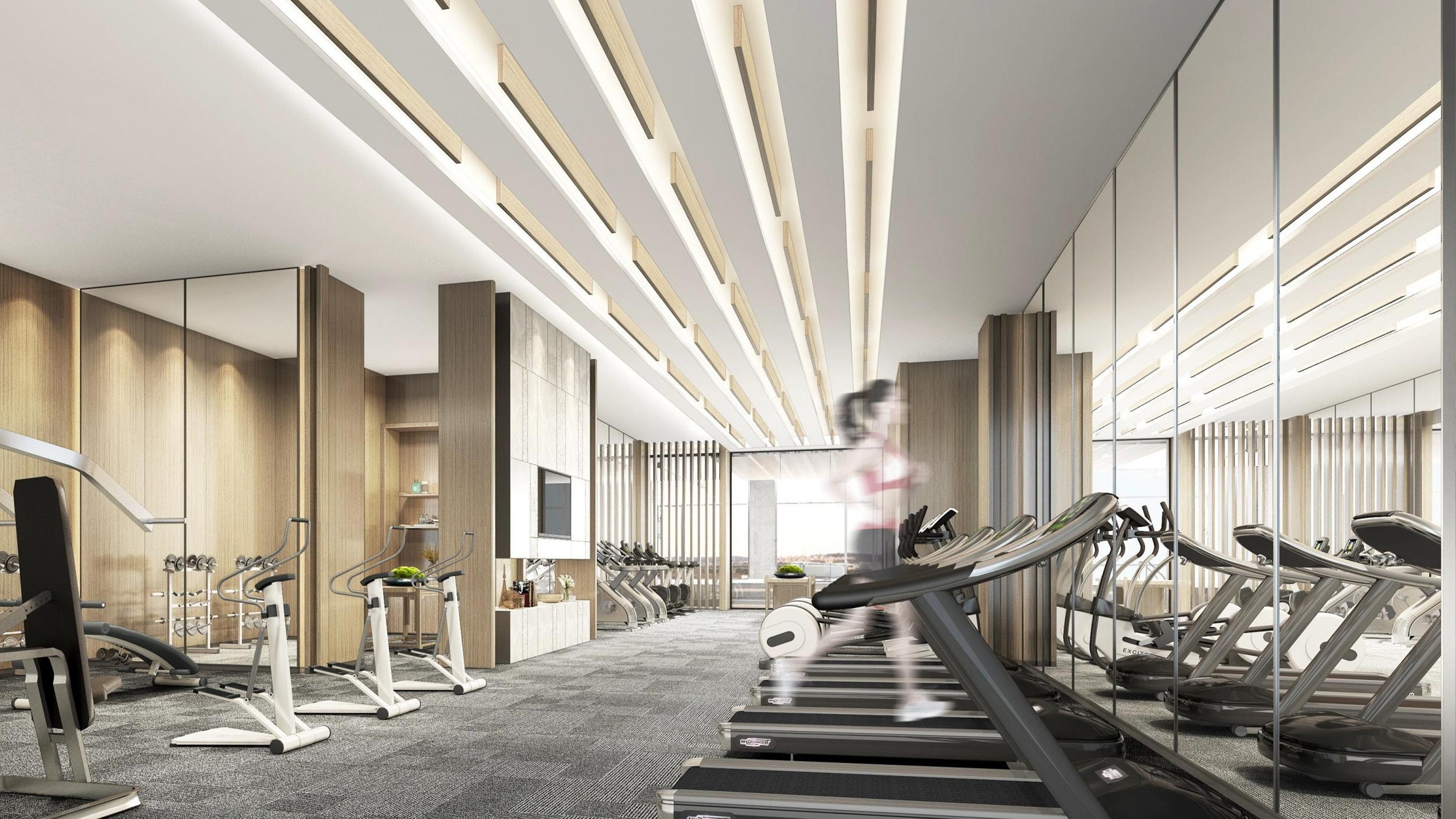 A modern gym with treadmills, stationary bikes, and weight machines.