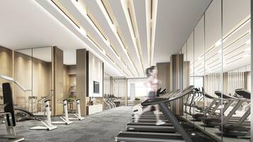 A modern gym with treadmills, stationary bikes, and weight machines.