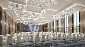 A spacious conference room with a high ceiling, modern chandeliers, and large windows offering a view of the outdoors. - Crowne Plaza Shangluo (Shanglou)