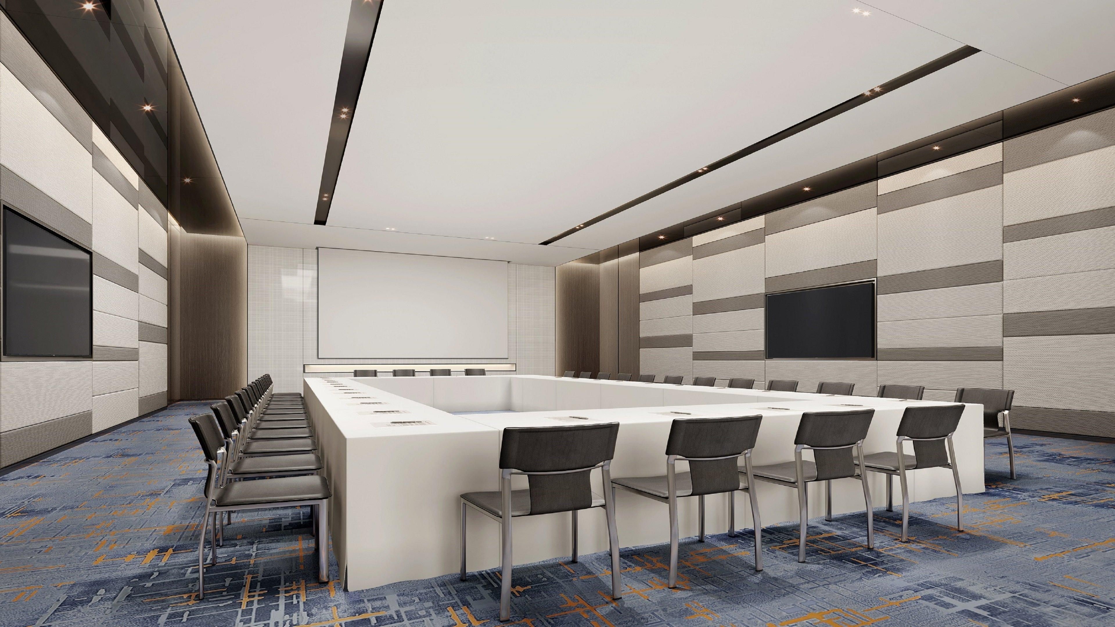 A conference room with a long table, chairs, a whiteboard, and a carpeted floor.