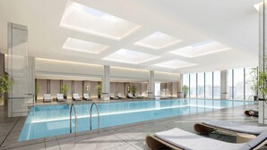 A modern indoor pool area with lounge chairs, a clear pool, and large windows offering city views. - Crowne Plaza Shangluo (Shanglou)