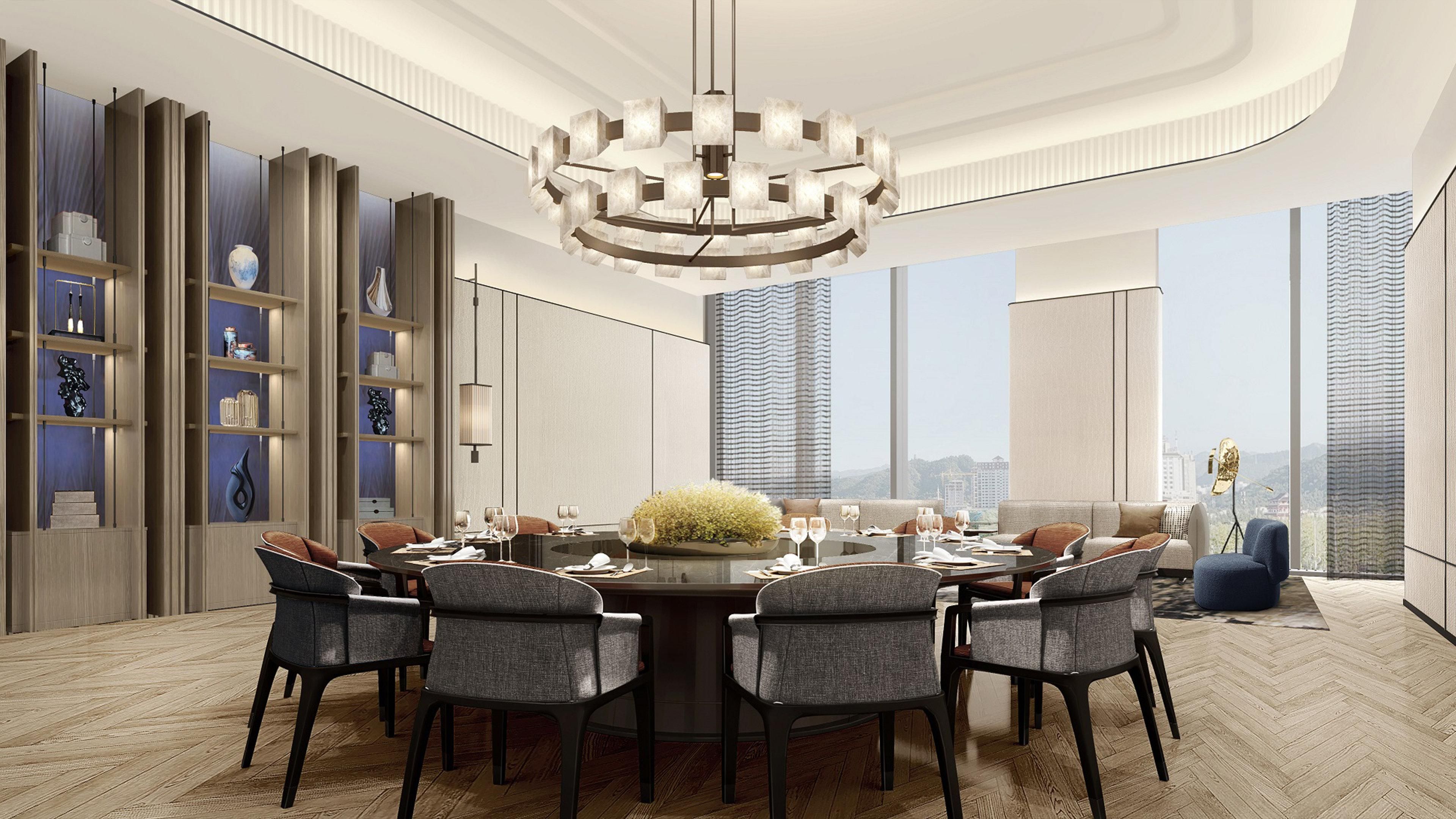 A modern dining area with a round table, grey upholstered chairs, and a central floral arrangement.