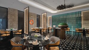 A modern dining area with round tables, checkered chairs, and a patterned floor. - Crowne Plaza Shangluo (Shanglou)