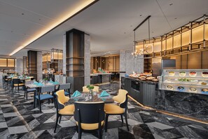 A modern restaurant with marble flooring, high ceilings, and a buffet area with various dishes.