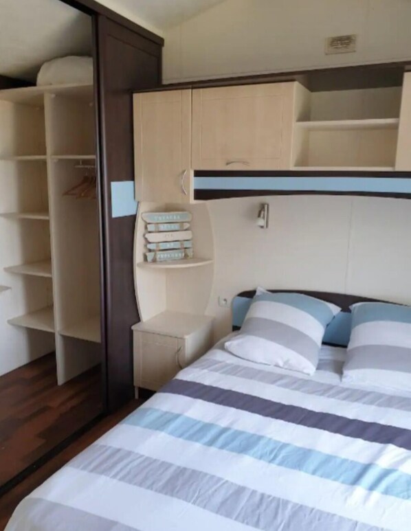 Une chambre à coucher comprenant un lit, une armoire et une étagère.