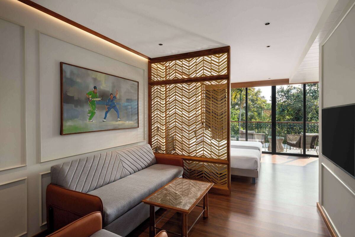 A modern living room with a sofa, a coffee table, a decorative screen, and a painting on the wall.