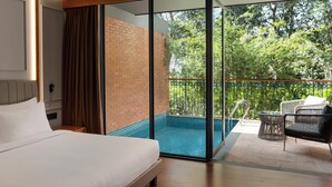 A hotel room with a bed, a glass door leading to a balcony with a pool and outdoor furniture. - Morickap Lord's 83, Trademark Collection by Wyndham (Sulthan Bathery)