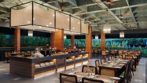 A restaurant with a long counter, multiple tables, and a ceiling with exposed beams. - Morickap Lord's 83, Trademark Collection by Wyndham (Sulthan Bathery)