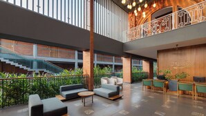 A spacious lobby with a high ceiling, a staircase, and seating areas. - Morickap Lord's 83, Trademark Collection by Wyndham (Sulthan Bathery)