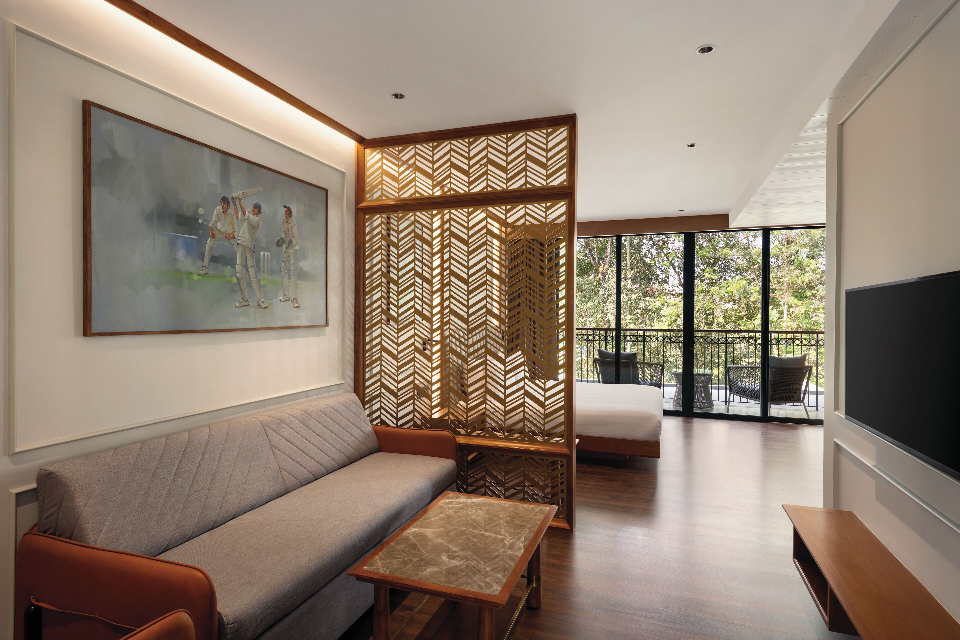 A modern living room with a sofa, a coffee table, a TV, and a large window with a view of the outdoors.