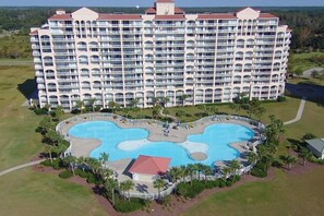 A large hotel with multiple balconies and a central swimming pool. - Vibrant Beachy Condo! Barefoot Landing Resort! Yacht Club Villa by the Beach! (North Myrtle Beach)