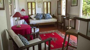 A bedroom with a bed, a red rug, a desk, and a chair.