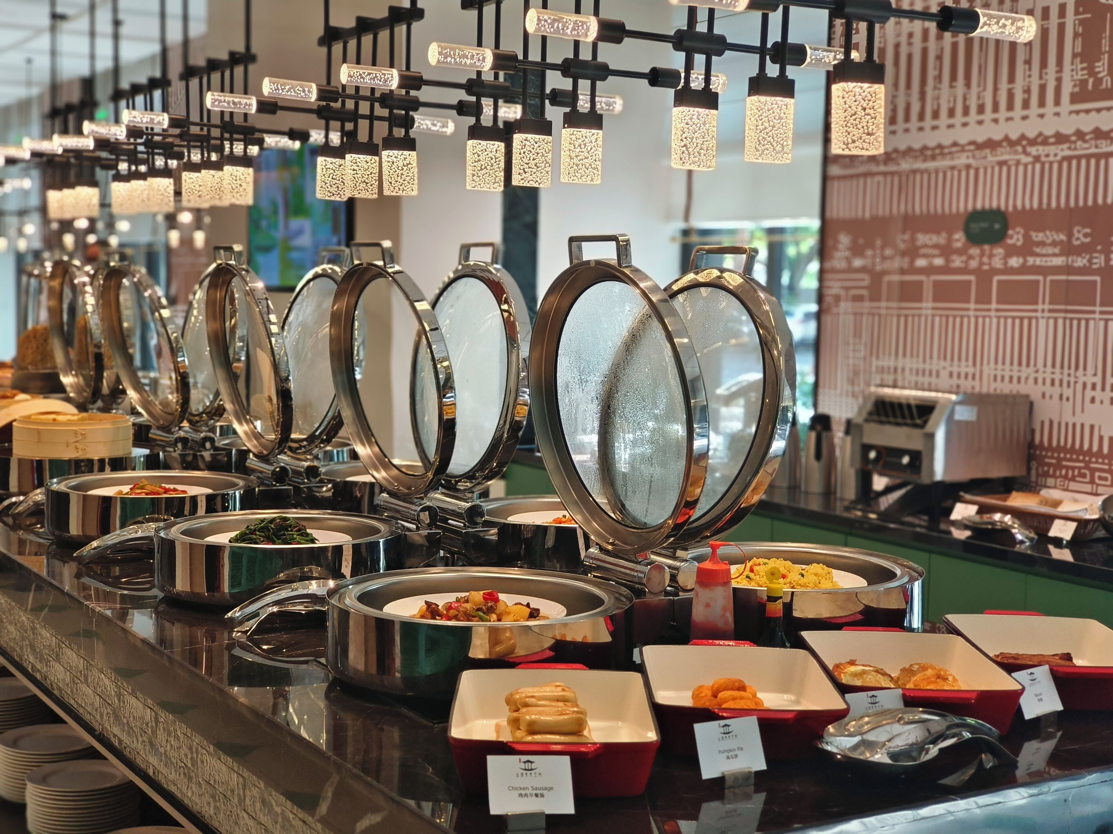 A buffet setup with multiple food stations, including a variety of dishes in containers and a selection of beverages.
