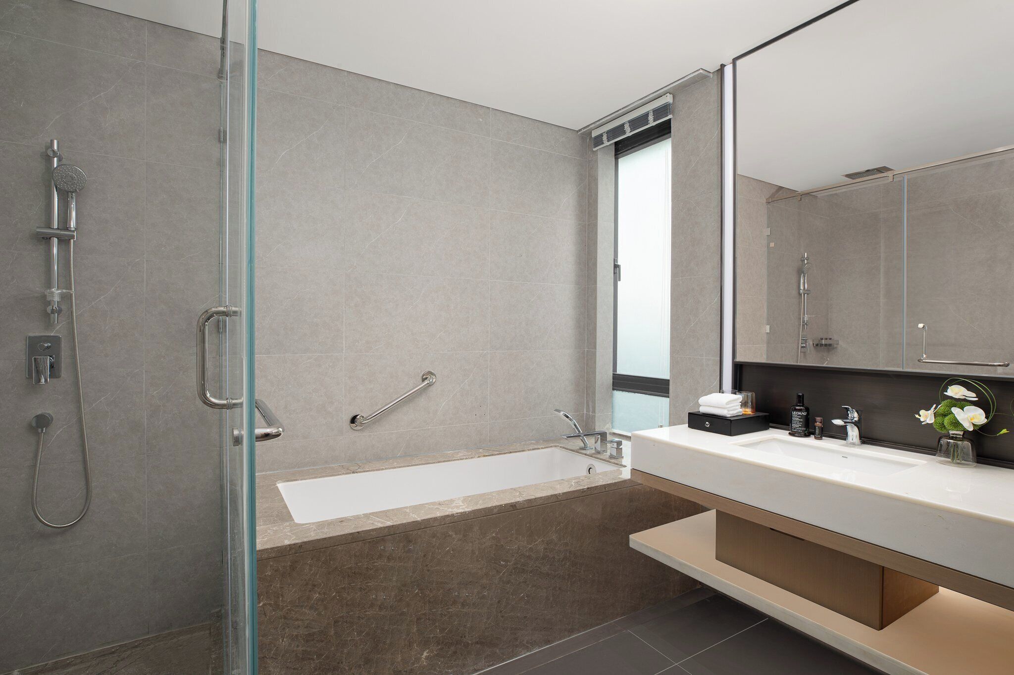 Een moderne badkamer met een douchecabine, een bad en een wastafel met spiegel.