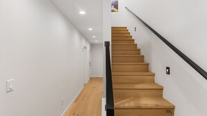 A staircase with wooden steps and a black handrail, leading to an upper floor. - Harry Potter Sweet Suites (Seattle)