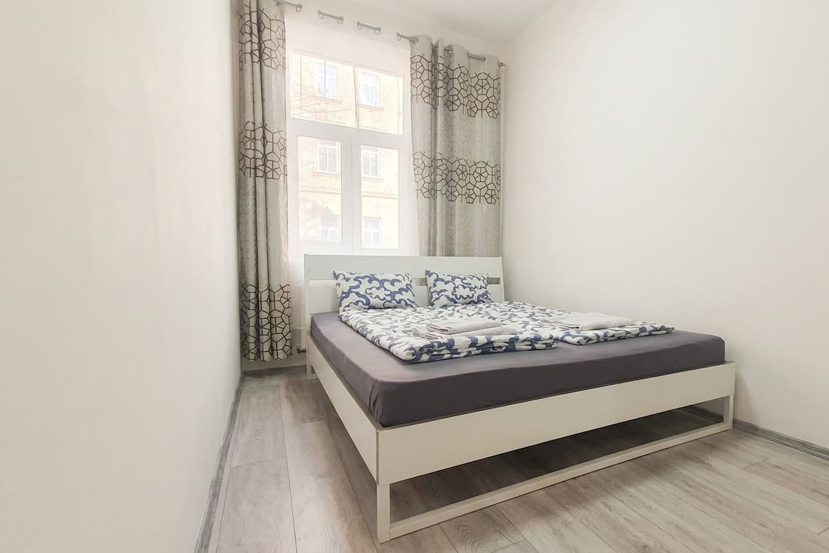 Un dormitorio con cama, cortinas y ventana.