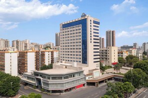 A high-rise hotel with a modern design, featuring a prominent glass facade and a rooftop terrace. - Days Inn by Wyndham Zhanjiang Economic Development Zone (Zhanjiang)