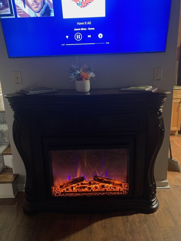 Ein Flachbildfernseher ist an einer Wand über einem Kamin mit Sims angebracht.