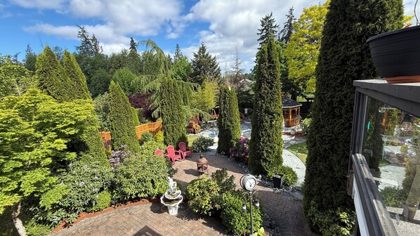 A garden with a gazebo, red chairs, and a fountain.