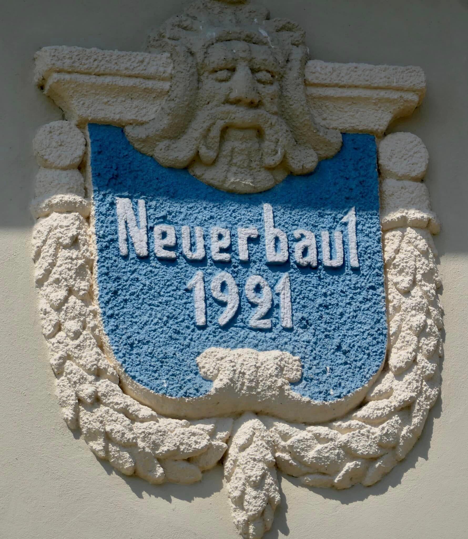 A stone plaque with the inscription "Neverbaum 1921" on a wall.
