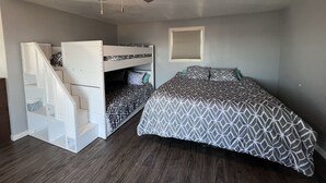 A compact bedroom with a bunk bed, a ceiling fan, and a window.