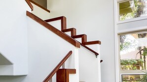 A staircase with wooden handrails and stone steps leading to an upper floor. - Tropical Ocean View! Escape to the Rainforest getaway of your dreams! (Keaau)