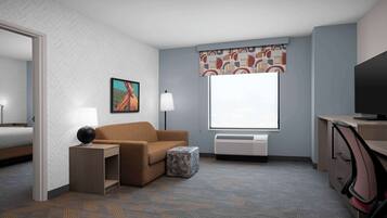 Ein Hotelzimmer mit Bett, Sofa, Schreibtisch mit Lampe, Fernseher und Fenster mit gemustertem Vorhang.