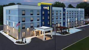 A modern hotel with a prominent 'HOME 2' sign, multiple entry points, and a well-lit parking area. - Home2 Suites By Hilton Chattanooga East Ridge (Chattanooga)