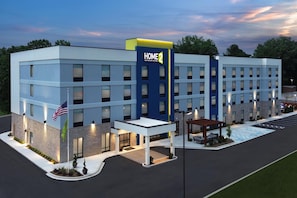 A modern hotel with a prominent 'HOME 2' sign, multiple entry points, and a well-lit parking area. - Home2 Suites By Hilton Chattanooga East Ridge (Chattanooga)