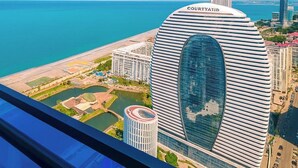 Un edificio alto con facciata curva e il nome "COURTYATID" sulla sommità.